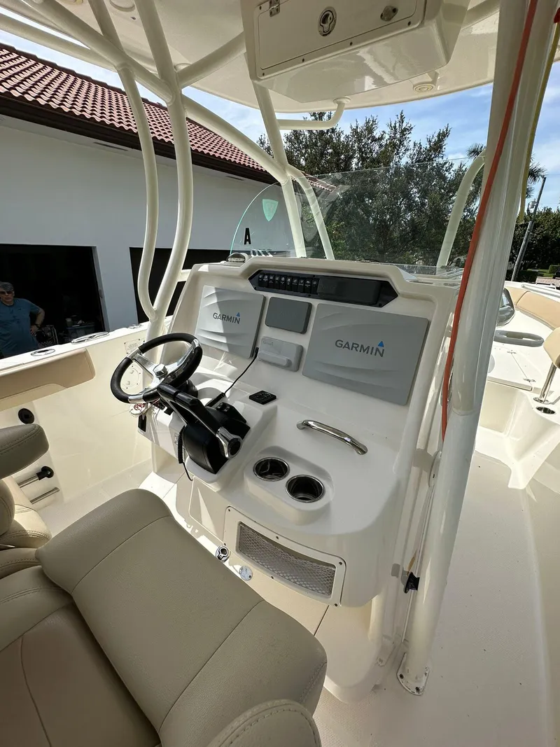 Slide: The Image of 2018 Sailfish 270 CC boat with beige seating, located outdoors near greenery. - 23