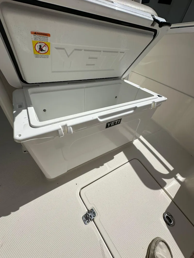 Slide: The Image of 2018 Sailfish 270 CC boat interior with seating, table, and storage compartments. - 25