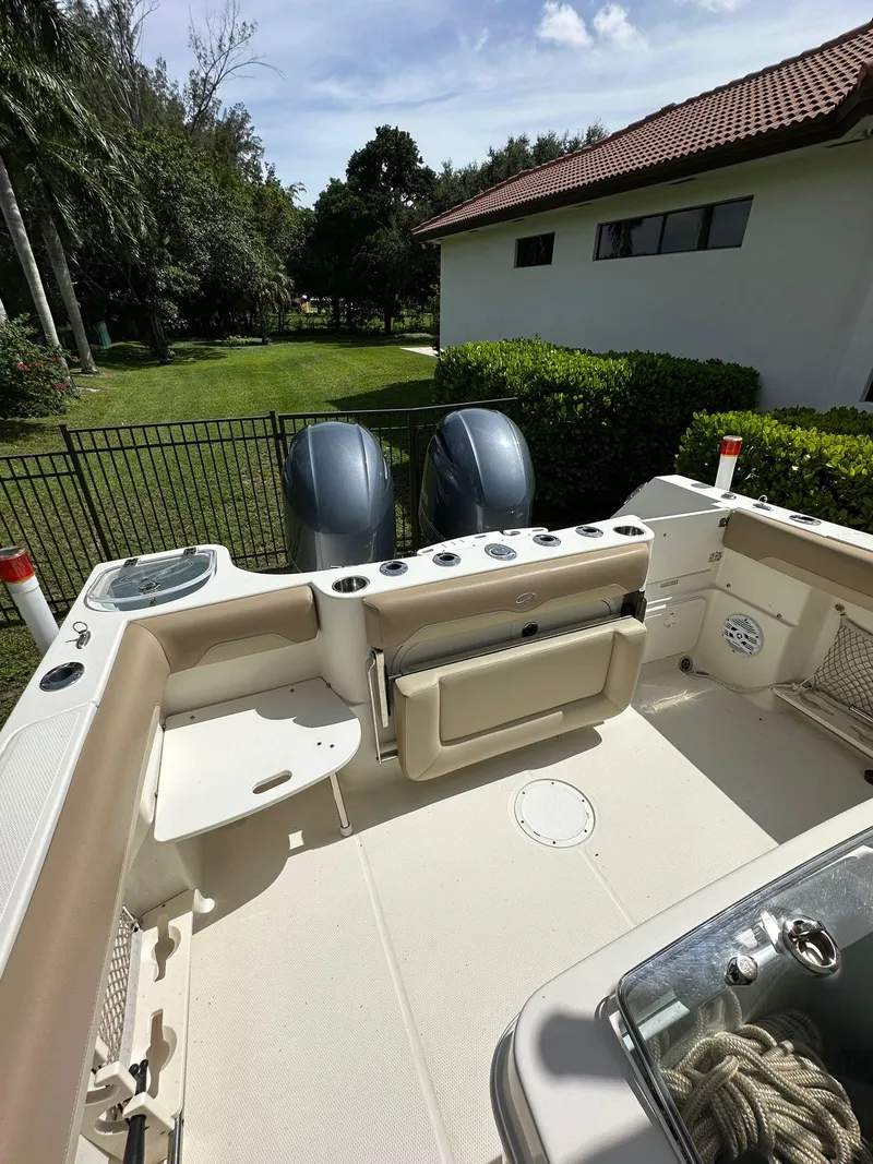 Slide: The Image of 2018 Sailfish 270 CC boat seat with beige cushion and Yeti cooler underneath. - 29
