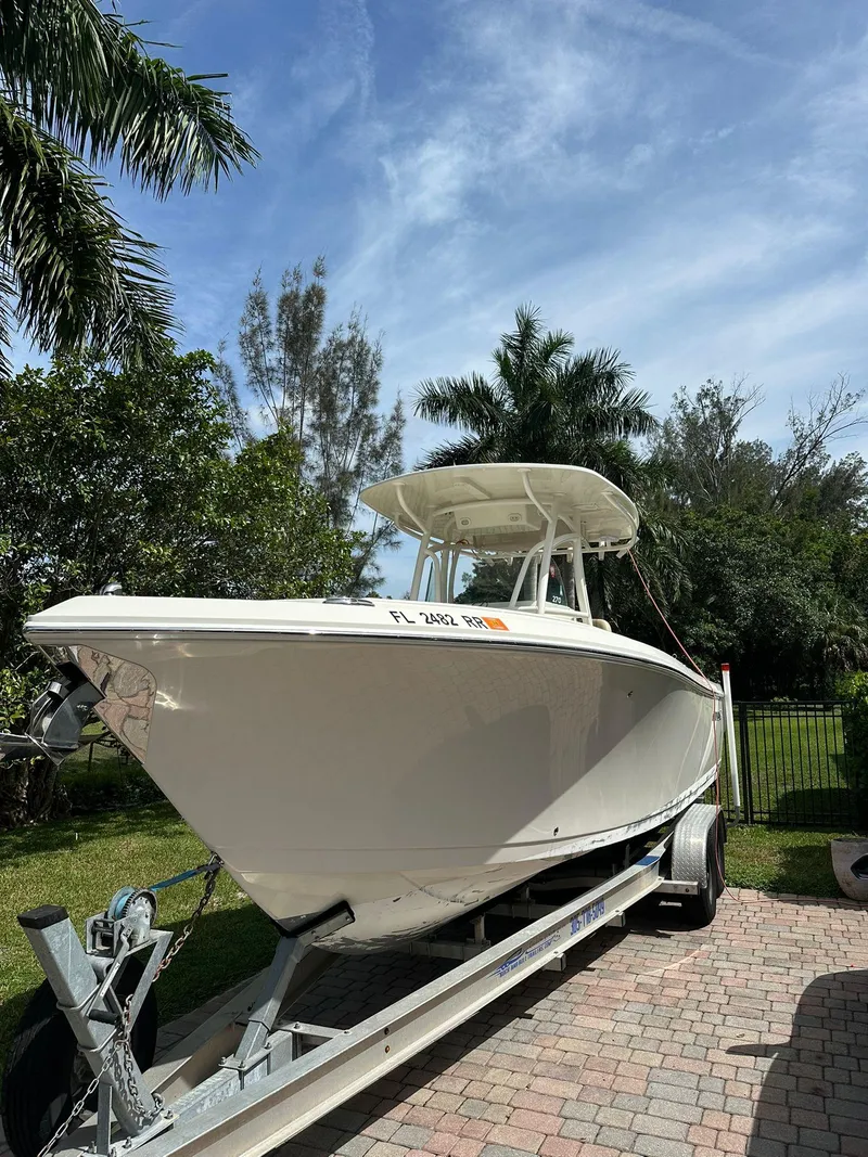 Slide: The Image of 2018 Sailfish 270 CC boat on trailer, parked outdoors with palm trees in background. - 3