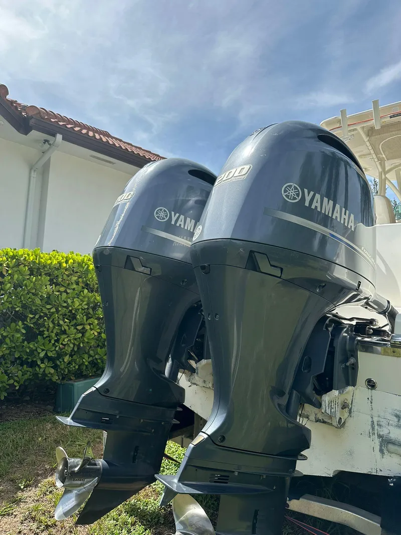 Slide: The Image of 2018 Sailfish 270 CC boat on trailer, parked outdoors near palm trees. - 5