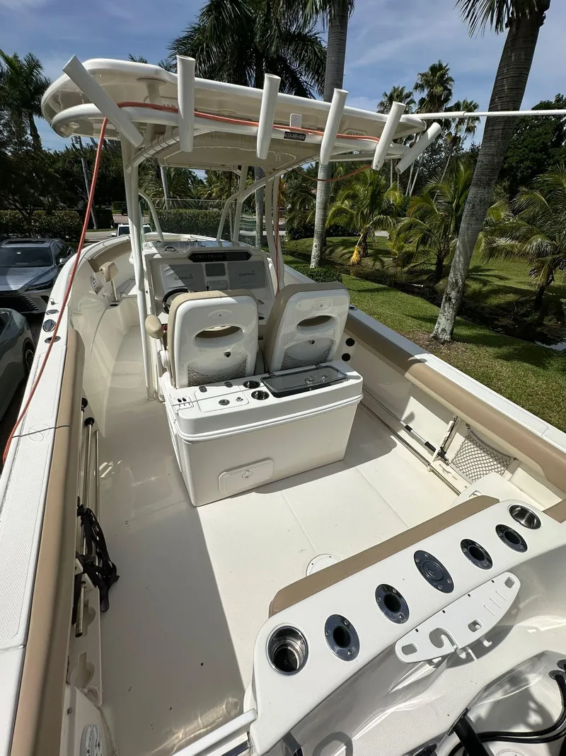 Slide: The Image of 2018 Sailfish 270 CC boat with dual outboard motors, docked outdoors. - 9