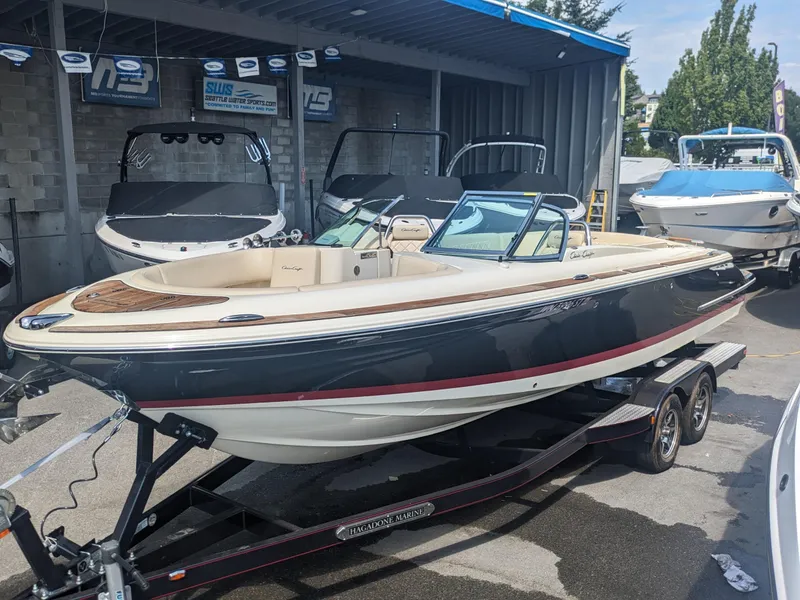 Slide: The Image of 2018 Chris-Craft Launch 27 boat on trailer at dealership, showcasing sleek design and luxury features. - 1