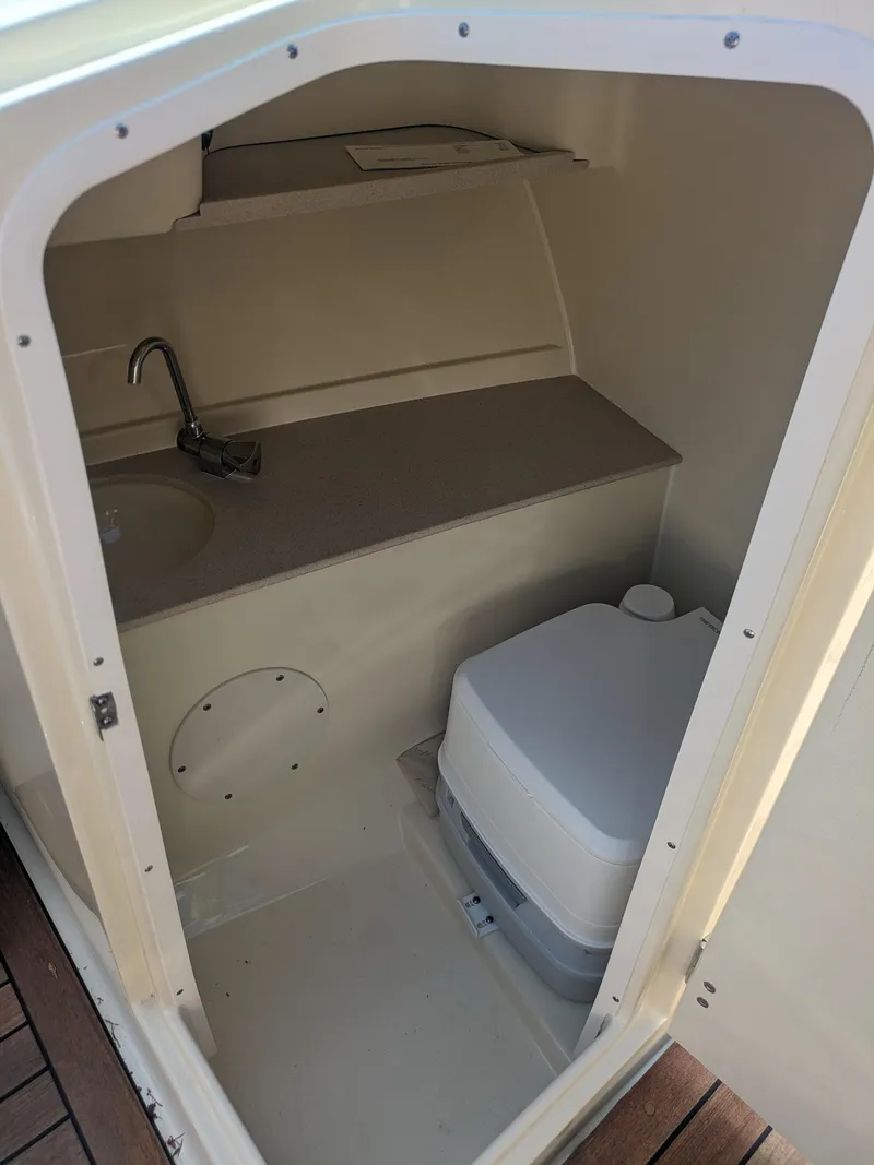 Slide: The Image of 2018 Chris-Craft Launch 27 boat interior with compact bathroom and portable toilet. - 12