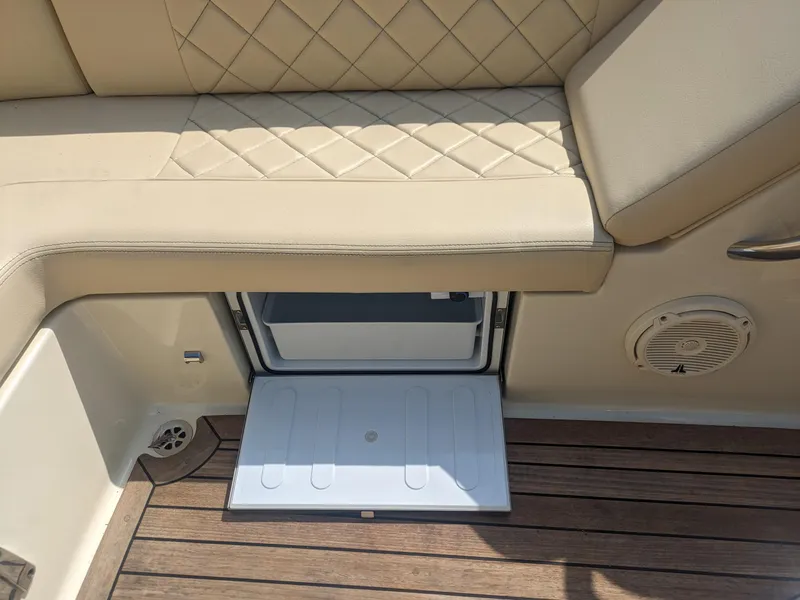 Slide: The Image of 2018 Chris-Craft Launch 27 interior with beige seating and open storage compartment. - 15