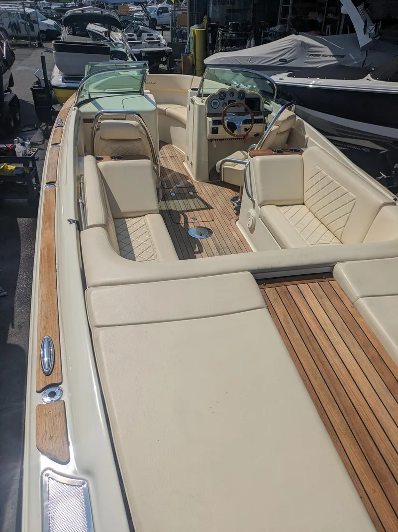 Slide: The Image of 2018 Chris-Craft Launch 27 boat with elegant beige interior and wooden deck. - 17