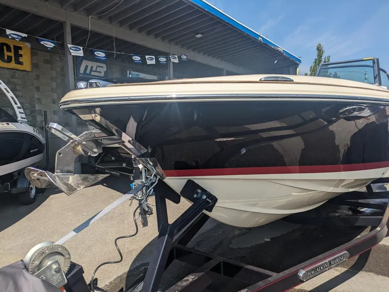 Slide: The Image of 2018 Chris-Craft Launch 27 boat on trailer at dealership, showcasing sleek design. - 3