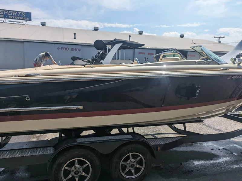 Slide: The Image of 2018 Chris-Craft Launch 27 boat on trailer, parked near a storage facility. - 5