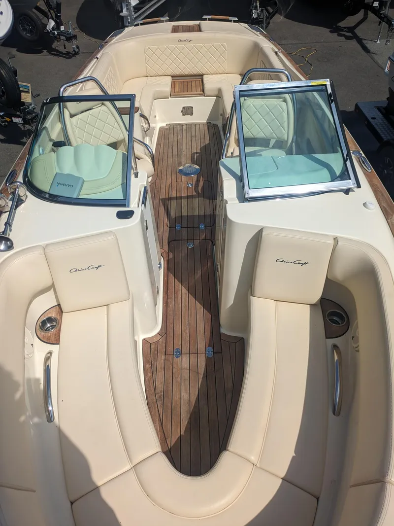 Slide: The Image of 2018 Chris-Craft Launch 27 boat interior with beige seating and wooden deck. - 6