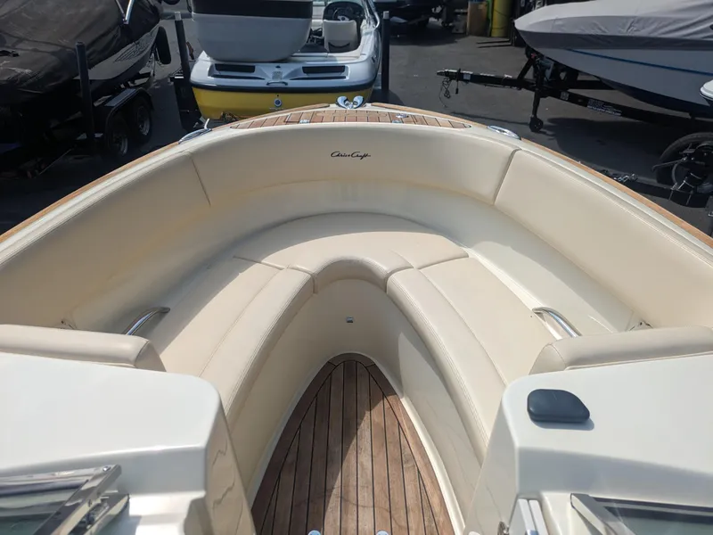 Slide: The Image of 2018 Chris-Craft Launch 27 boat interior with beige seating and wooden flooring. - 7