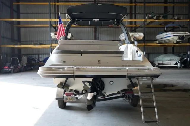 Slide: The Image of 2022 Sea Ray SDX 270 boat in storage, rear view with ladder and American flag. - 4