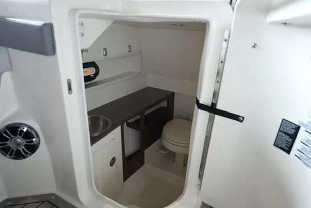 Slide: The Image of 2022 Sea Ray SDX 270 boat interior with compact bathroom and sink. - 9