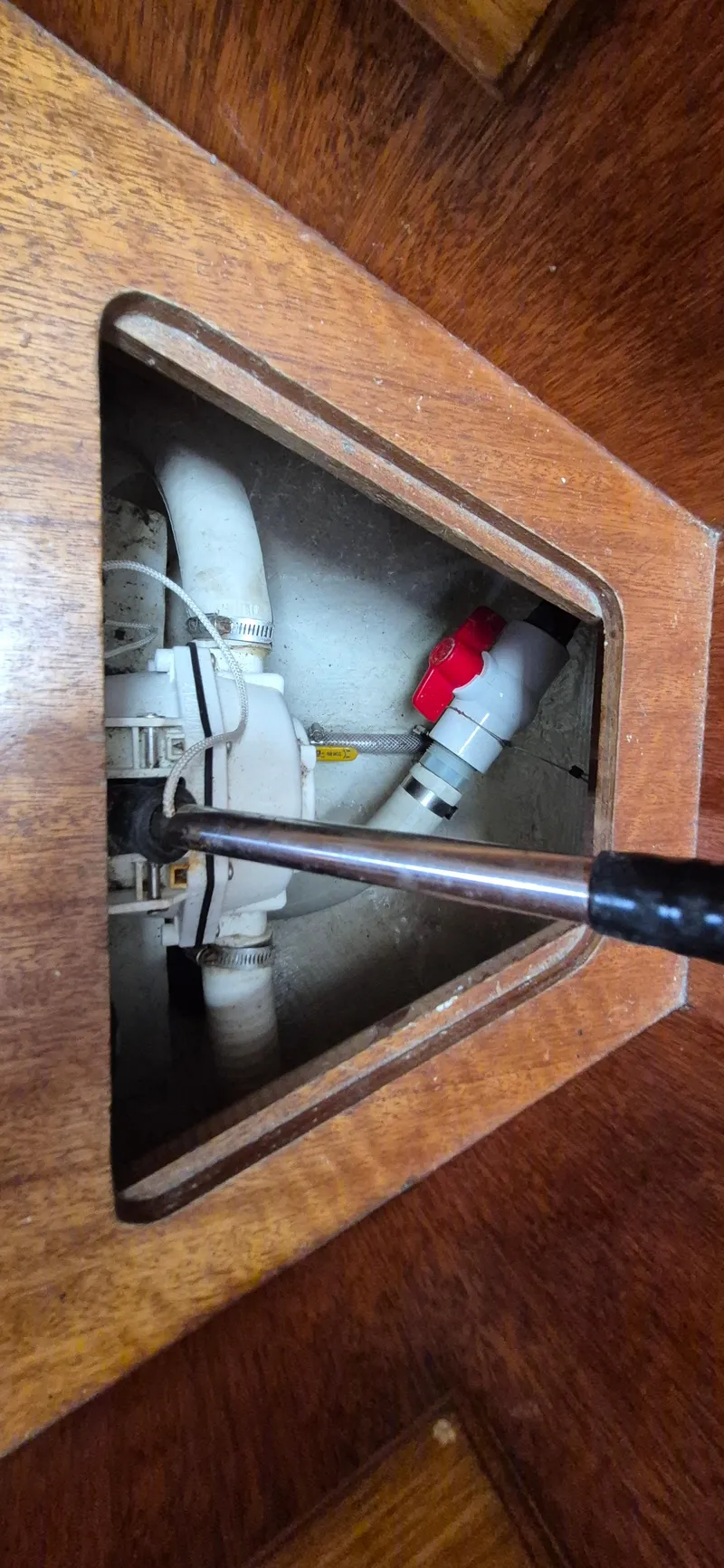 Slide: The Image of Wooden compartment with plumbing components inside a 1979 Bristol 35.5 boat. - 19