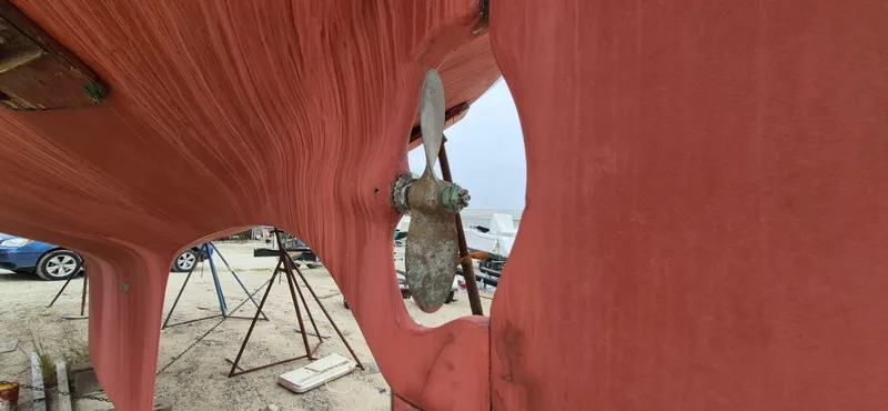 Slide: The Image of 1979 Bristol 35.5 sailboat hull with visible propeller, on stands in a boatyard. - 20