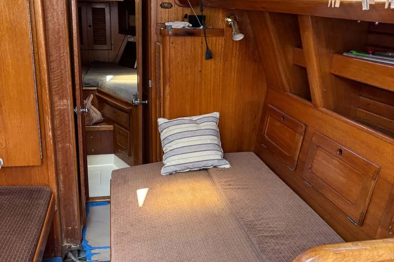 Slide: The Image of Interior of a 1979 Bristol 35.5 sailboat with wooden paneling and cozy seating area. - 3