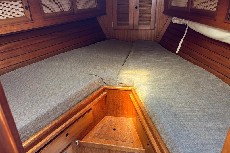 Slide: The Image of Cozy cabin interior of a 1979 Bristol 35.5 sailboat with wooden paneling and twin beds. - 4