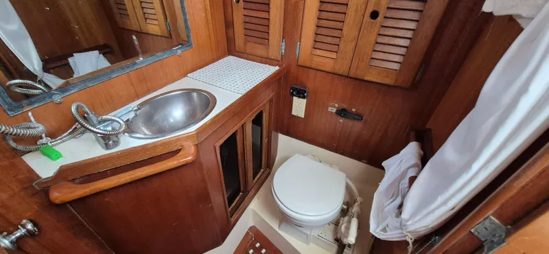 Slide: The Image of 1979 Bristol 35.5 yacht bathroom with wooden cabinets, sink, and toilet. - 7