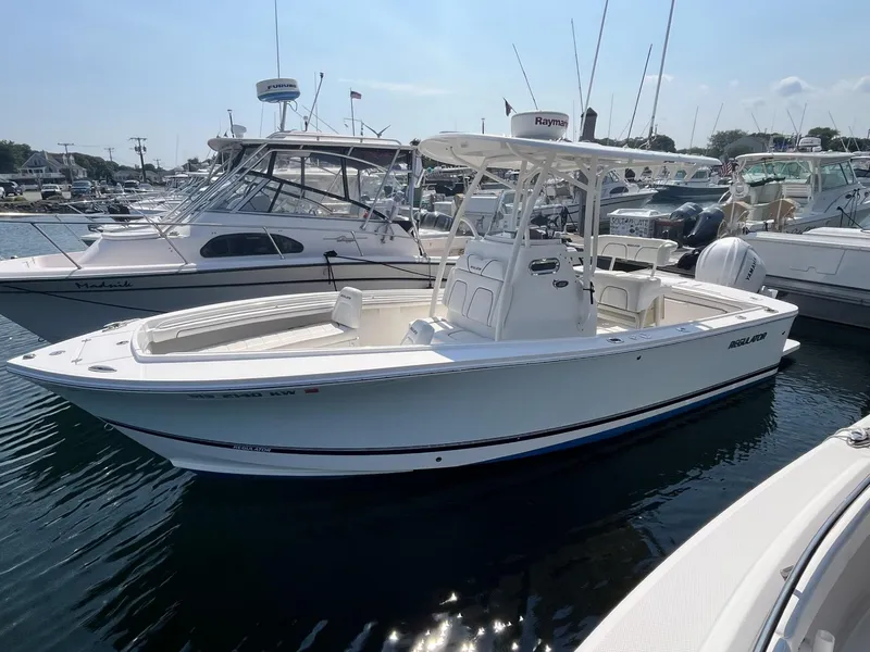 Slide: The Image of 2016 Regulator 23 boat docked in a marina, surrounded by other vessels. - 0