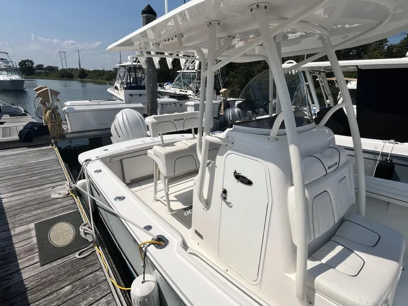 Slide: The Image of 2016 Regulator 23 boat docked at marina, featuring white seating and console. - 10