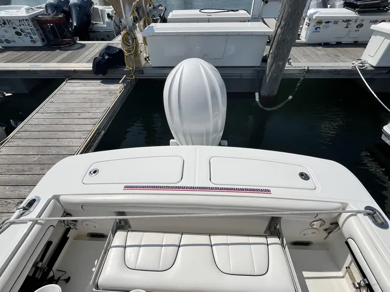 Slide: The Image of 2016 Regulator 23 boat docked, showcasing rear seating and outboard motor. - 12