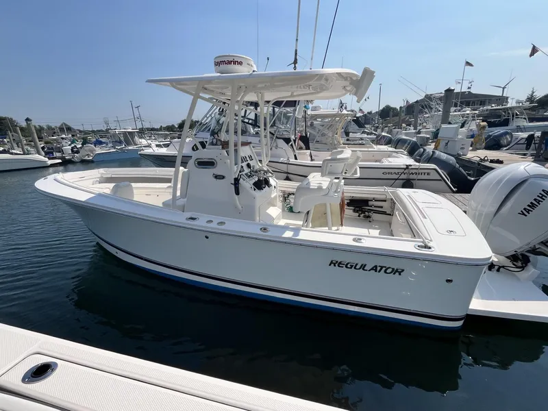 Slide: The Image of 2016 Regulator 23 boat docked in marina, featuring Yamaha outboard engine. - 2