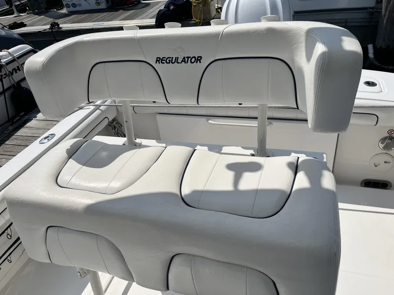 Slide: The Image of 2016 Regulator 23 boat seat with white upholstery and logo. - 21