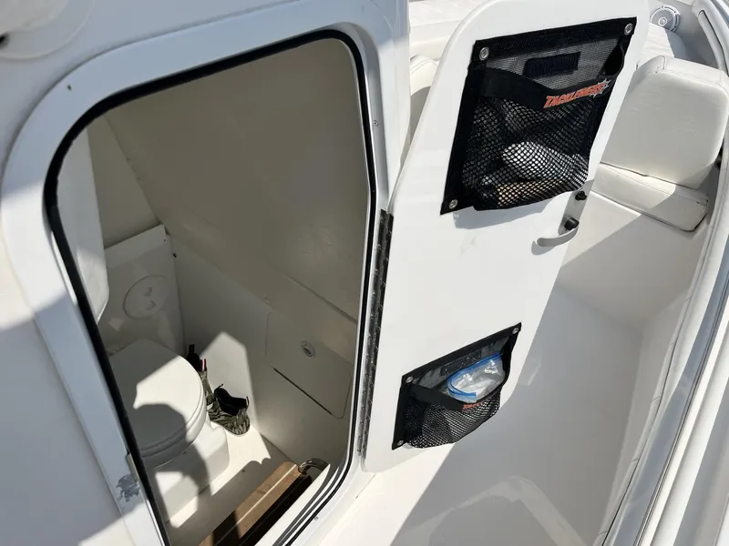 Slide: The Image of 2016 Regulator 23 boat interior with open door revealing compact toilet area. - 27
