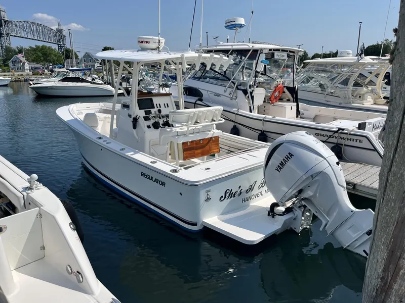 Slide: The Image of 2016 Regulator 23 boat docked, featuring Yamaha outboard motor, in a marina setting. - 3