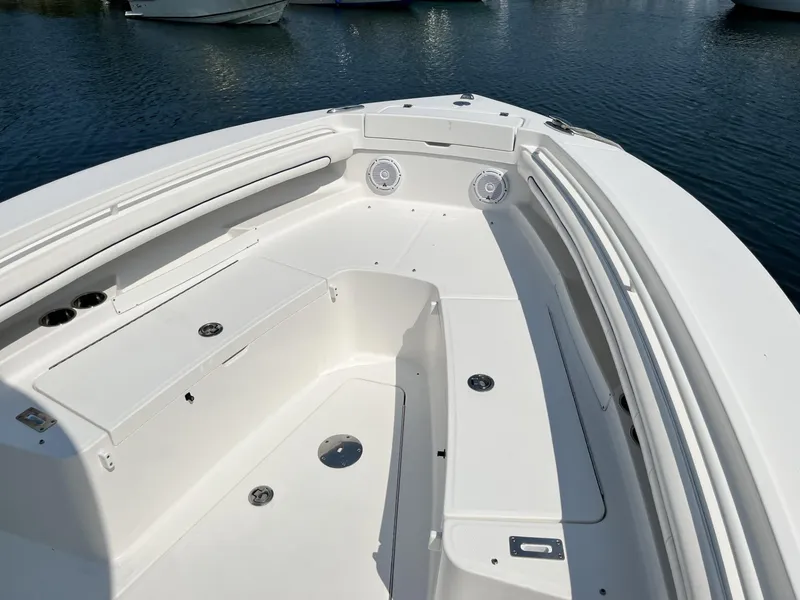 Slide: The Image of 2016 Regulator 23 boat interior with seating and storage, docked on calm water. - 38