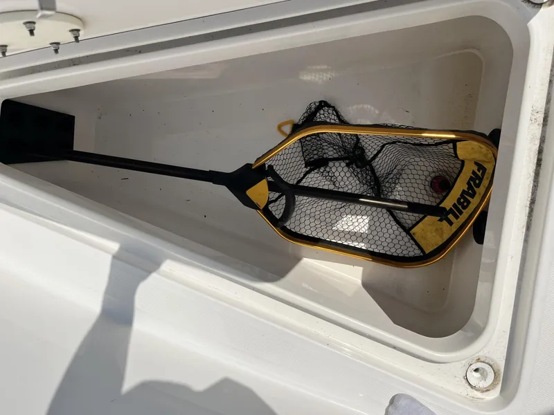Slide: The Image of Storage compartment on 2016 Regulator 23 boat with a fishing net inside. - 40