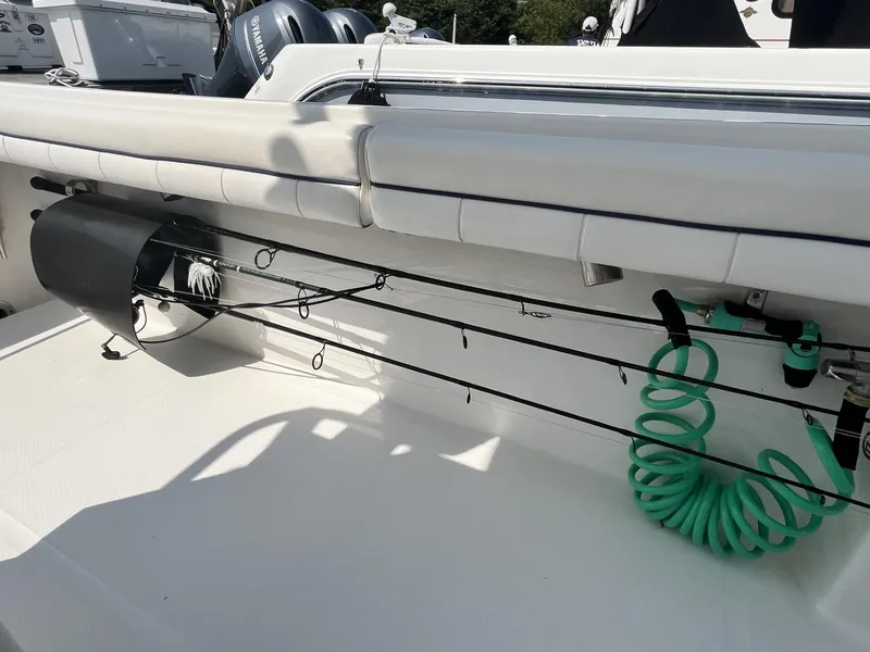 Slide: The Image of 2016 Regulator 23 boat interior with fishing rods and coiled hose. - 41