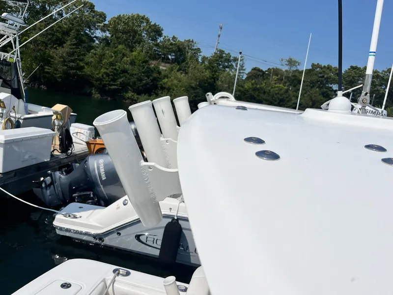 Slide: The Image of 2016 Regulator 23 boat with Yamaha engine docked, featuring rod holders and Simrad equipment. - 43