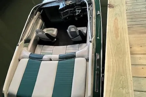 Slide: The Image of 1988 Sea Ray Pachanga 22 boat docked, featuring green and white interior seating. - 5