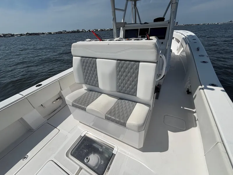 Slide: The Image of 2022 Invincible 36 Open Fisherman boat interior with cushioned seating on open water. - 16