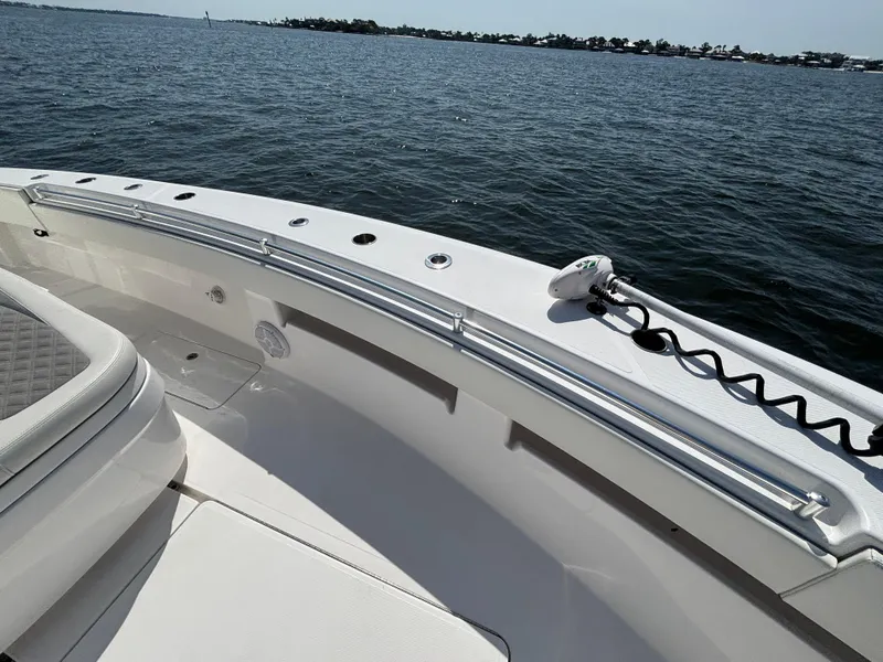 Slide: The Image of 2022 Invincible 36 Open Fisherman boat on calm water, showcasing sleek design and spacious deck. - 17