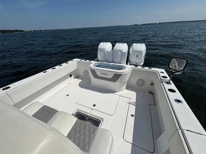 Slide: The Image of 2022 Invincible 36 Open Fisherman boat on water, featuring spacious deck and triple engines. - 28