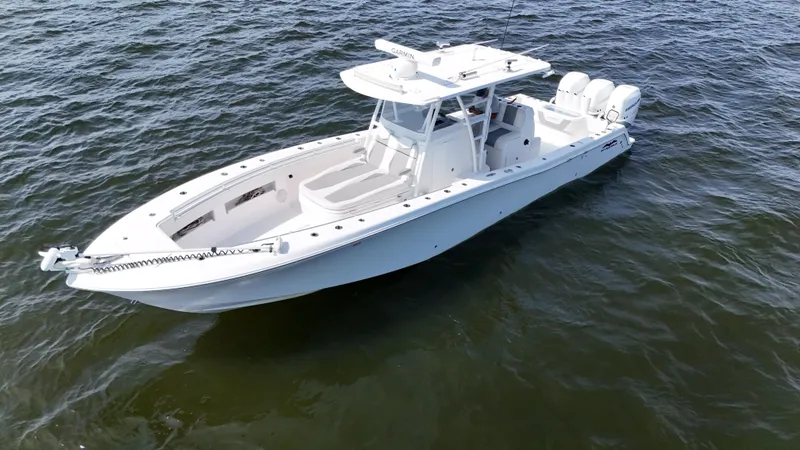 Slide: The Image of 2022 Invincible 36 Open Fisherman boat on open water, featuring sleek design and triple engines. - 9