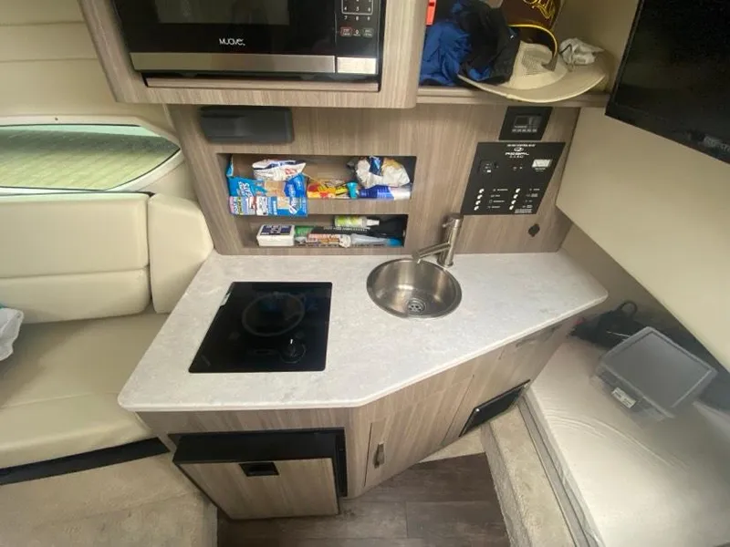 Slide: The Image of Compact kitchen area in a 2019 Regal 26 Express boat with sink and stove. - 12