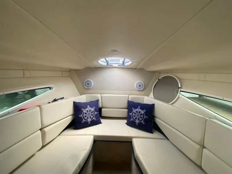 Slide: The Image of Interior of 2019 Regal 26 Express boat with beige seating and nautical-themed pillows. - 14