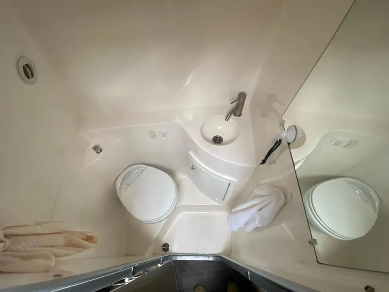 Slide: The Image of Compact bathroom in 2019 Regal 26 Express boat with toilet, sink, and mirror. - 15