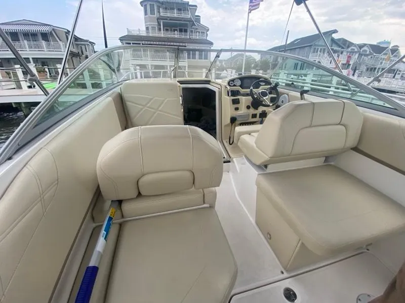 Slide: The Image of 2019 Regal 26 Express boat interior with beige seating and steering console. - 4