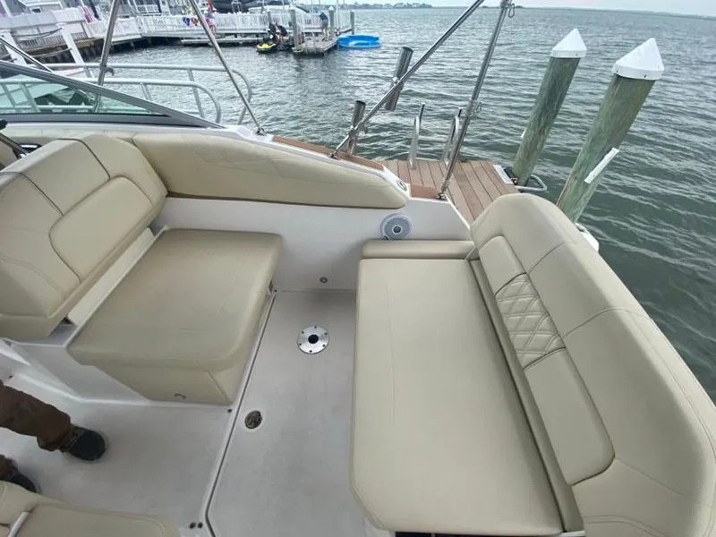 Slide: The Image of 2019 Regal 26 Express boat interior with beige seating, docked by the water. - 5