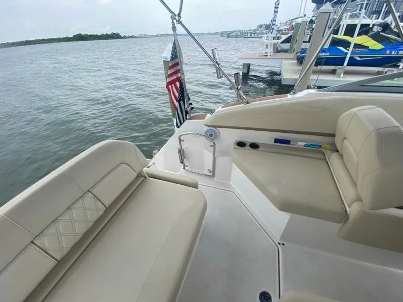 Slide: The Image of 2019 Regal 26 Express boat interior with beige seating, docked by the water. - 6