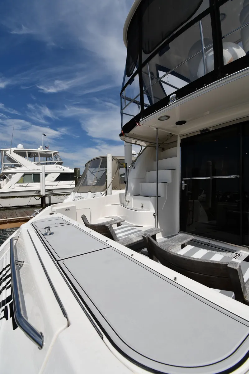 Slide: The Image of 2001 Sea Ray 480 Sedan Bridge yacht docked under a clear blue sky. - 10