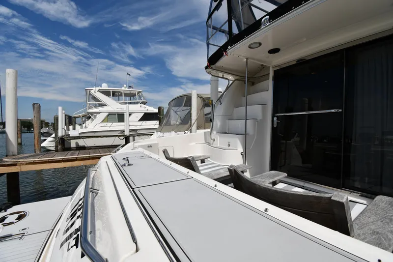 Slide: The Image of 2001 Sea Ray 480 Sedan Bridge yacht docked at marina under blue sky. - 11