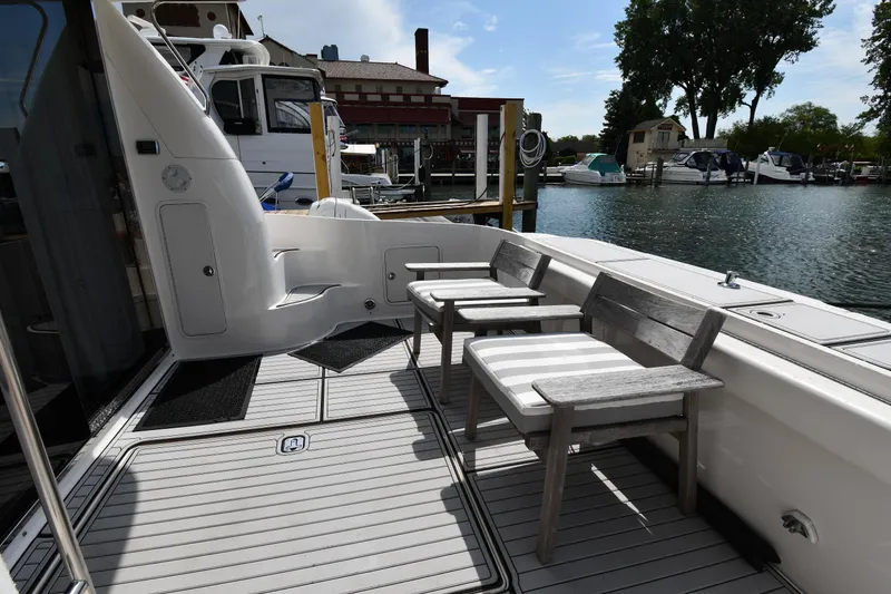 Slide: The Image of 2001 Sea Ray 480 Sedan Bridge yacht deck with chairs, docked at marina. - 13