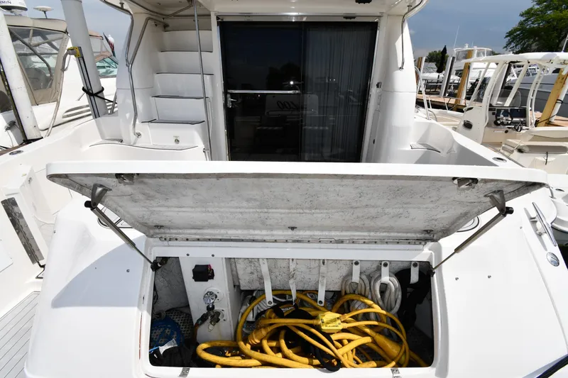 Slide: The Image of 2001 Sea Ray 480 Sedan Bridge yacht with open storage compartment and coiled cables. - 14