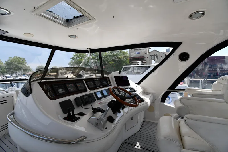 Slide: The Image of Interior view of 2001 Sea Ray 480 Sedan Bridge yacht cockpit with modern controls and seating. - 19