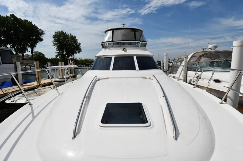 Slide: The Image of 2001 Sea Ray 480 Sedan Bridge yacht docked at marina under blue sky. - 2