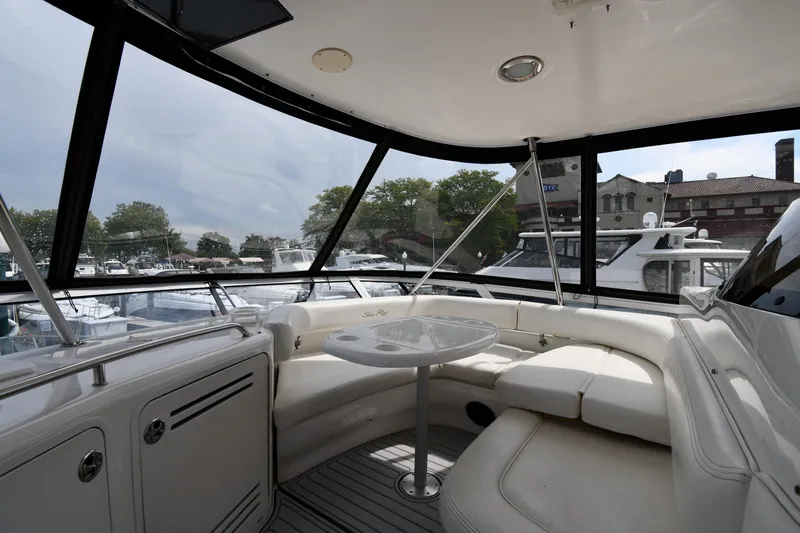 Slide: The Image of 2001 Sea Ray 480 Sedan Bridge interior with seating and table, docked at marina. - 30